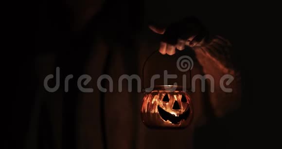 女人拿着万圣节南瓜脸上挂着吓人的蜡烛视频的预览图