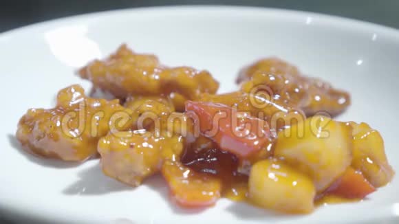 糖醋酱鸡肉在昂贵的咖啡馆或餐厅特写的白色盘子上的美味菜肴视频的预览图