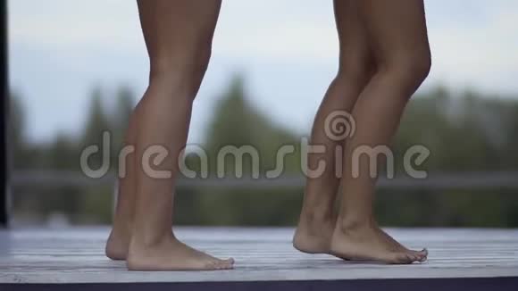 两条翩翩起舞的修长黝黑的女腿一个周末女孩们在游泳池附近的休息室玩得很开心视频的预览图