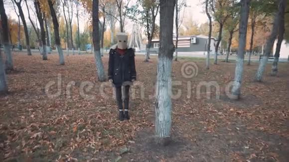 头上戴背包的女孩躲在树后面穿夹克的女孩视频的预览图