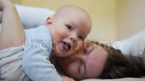 在卧室里一个婴儿在晨床上妈妈怀里的亲密画像视频的预览图