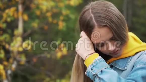 美丽的学生女孩微笑着在公园里梳着长发学习期间休息视频的预览图