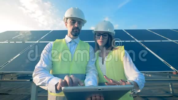 两名工人站在太阳能电池板背景上关门视频的预览图