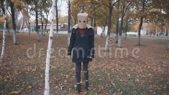 头上戴背包的女孩躲在树后面穿夹克的女孩视频的预览图