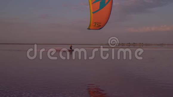 一个人在浅水处从事风筝冲浪人们在岸上休息视频的预览图