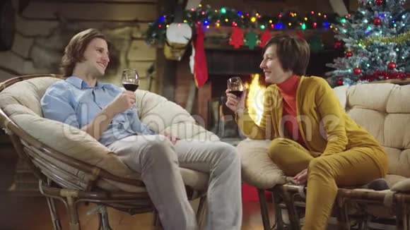 年轻的男人和快乐的成年女人在圣诞节喝酒和交谈视频的预览图