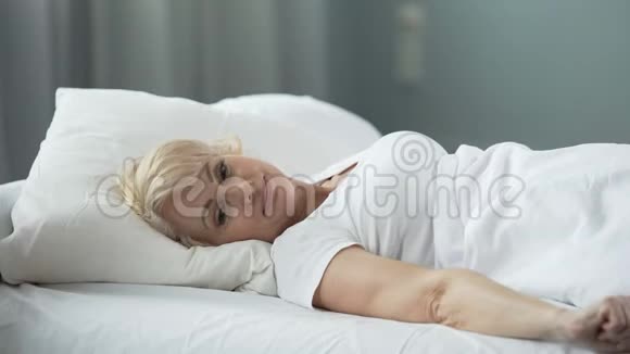 快乐的老年女性躺在床上想着完美的约会性健康视频的预览图