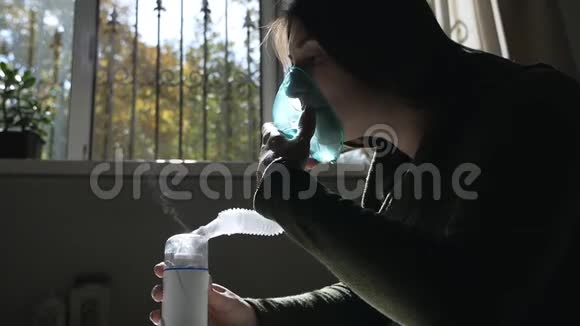 使用雾化器和吸入器进行治疗年轻女性通过吸入面罩吸入侧视图视频的预览图