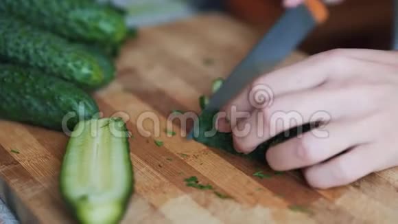 用刀子在木板上切黄瓜把女人的手收起来概念蔬菜视频的预览图