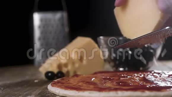 厨师用番茄酱在一个大比萨饼上擦奶酪意大利自制披萨视频的预览图