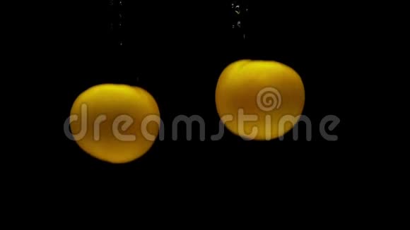 两个黄色的断层落在黑色背景的透明水中视频的预览图