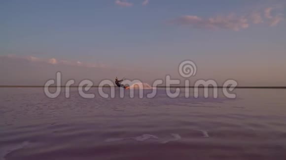 一个戴着头盔的人在玩风筝冲浪用照相机跳过去表演一个把戏视频的预览图