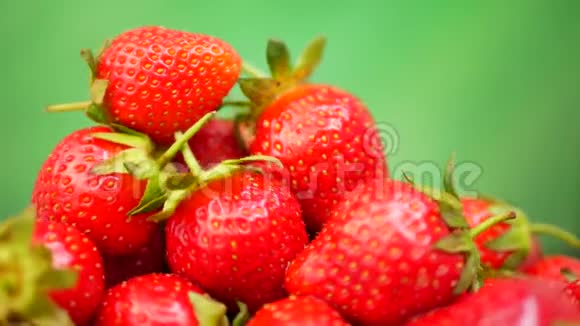 新鲜草莓放在绿色背景的碗里视频的预览图
