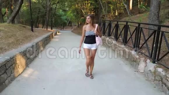 在公园里散步的漂亮晒黑的女人视频的预览图