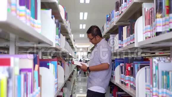 男大学生在图书馆过道看书视频的预览图