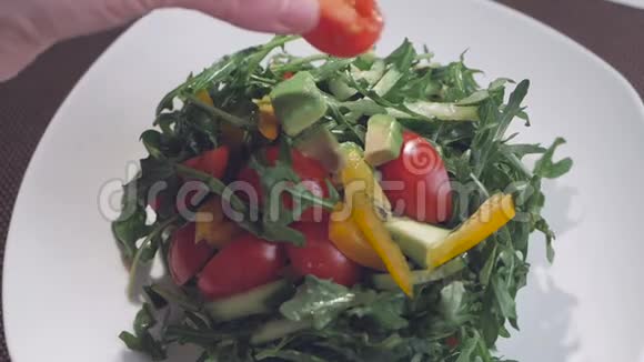 一位女厨师正准备提供一份木耳西红柿和甜椒沙拉盘子里的盘子视频的预览图