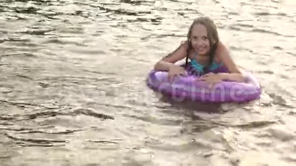穿着泳衣的女孩随波逐流在水里玩着救生圈笑着海滩季节视频的预览图