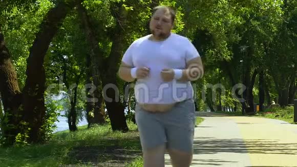 肥胖男子在户外跑步努力工作取得成绩超重计划视频的预览图