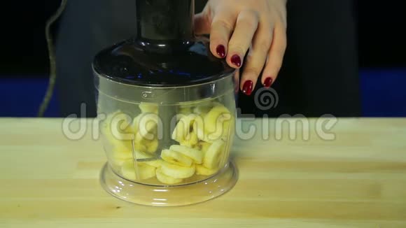 一个女人在搅拌器碗里切香蕉视频的预览图