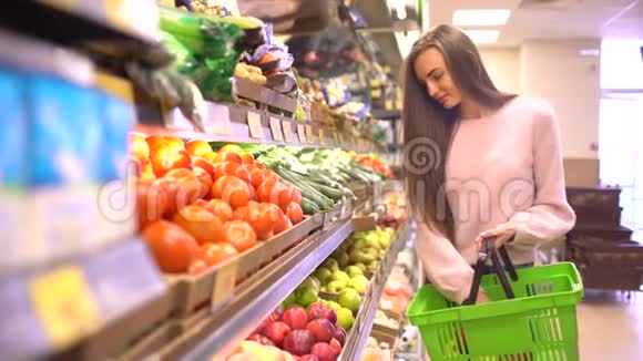 超市里的女人来到水果柜台她选择把苹果放进塑料袋里视频的预览图