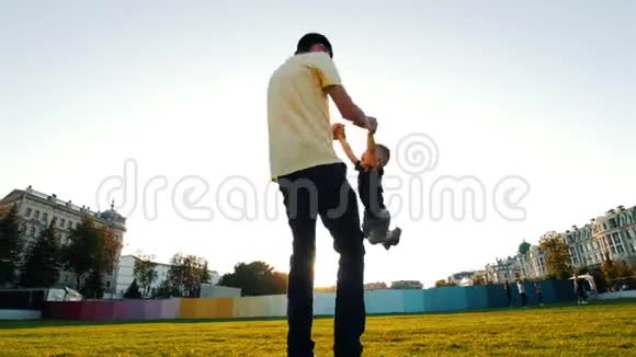 一个人在公园里抱着一个小男孩转圈阳光灿烂视频的预览图