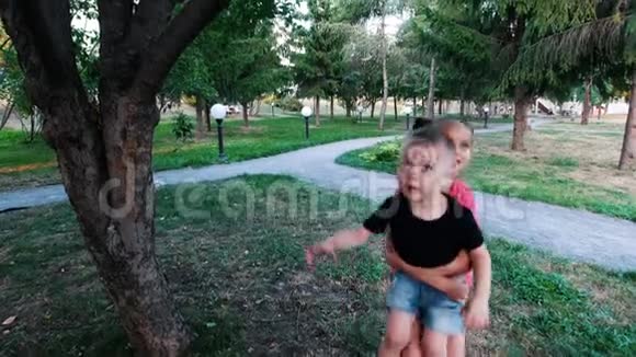 小女孩把弟弟抱在怀里伸到树枝上男孩伸出手与两人保持联系视频的预览图
