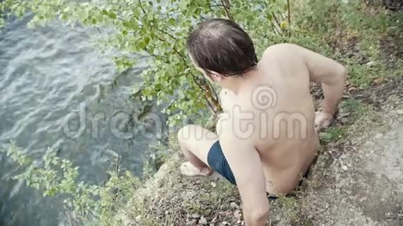 一个年轻人在河里跳跃勇敢的动作慢动作视频的预览图