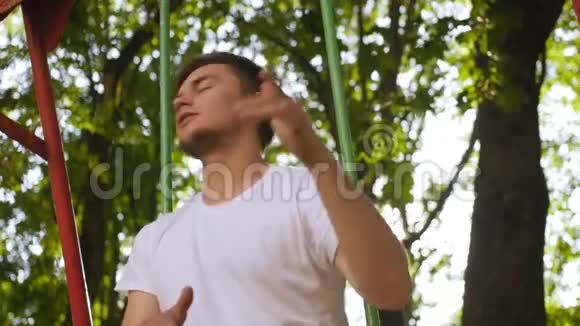 夏天一个穿着白色衬衫的人在树叶中的操场上嬉戏中弹视频的预览图