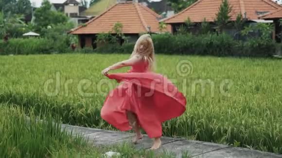 一个身材婀娜多姿身材婀娜的姑娘穿着一件飘逸的丝绸红色长裙翩翩起舞视频的预览图