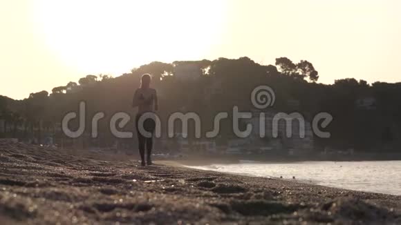 日出时运动女性沿着沙滩奔跑视频的预览图