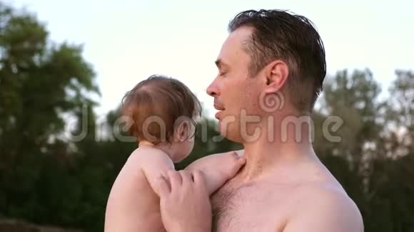 小湿澡的孩子笑了坐在快乐父亲的怀里视频的预览图