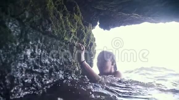 年轻女子在洞穴里游泳动作缓慢视频的预览图