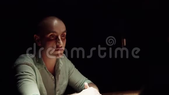成熟好看的男人坐在黑暗的房间里围着木桌说话视频的预览图