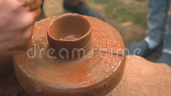 旋转陶工的车轮和粘土器皿从上面一只手在陶工的车轮上用泥杯雕刻视频的预览图