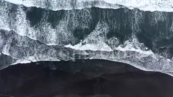 空中无人驾驶飞机在黑色火山沙上向海岸冲去的海浪大西洋冰岛视频的预览图