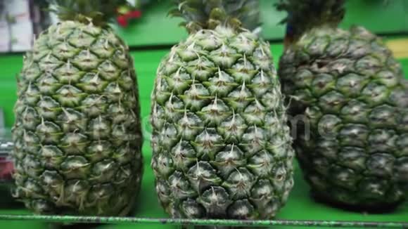 新鲜成熟的有机菠萝在当地菜市场的货架上出售视频的预览图