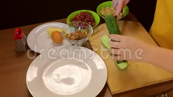 女人把新鲜的绿色黄瓜切在木板上时间跨度视频的预览图