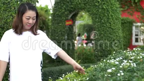 亚洲女人在公园里散步用手触摸植物视频的预览图