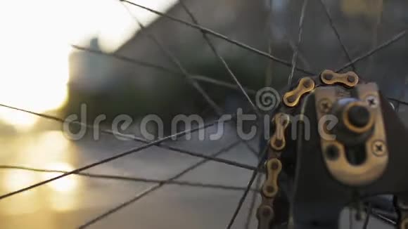 在城市日落时旋转自行车轮特写生态城市交通视频的预览图
