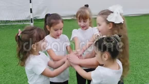 孩子们在室内踢足球孩子们在做团队支持手的手势视频的预览图