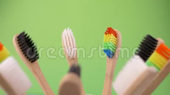 五颜六色的专业软牙刷在绿色背景上直切有很多刚毛视频的预览图