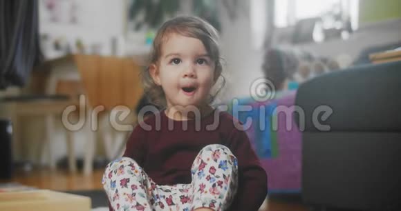 一个可爱有趣的小学步女孩在家的肖像视频的预览图