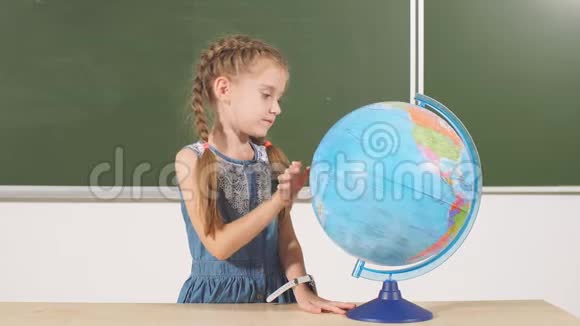 教室背景黑板上有地球仪的女学生视频的预览图