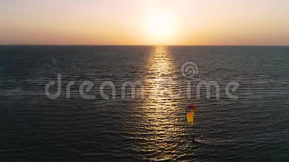海上日落的倒影一个孤独的风筝在海里驾驶一只训练风筝慢动作视频的预览图
