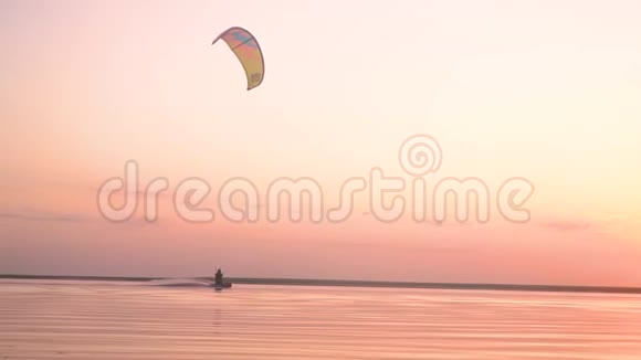粉红湖上美丽的日落一只男子风筝表演魔术视频的预览图