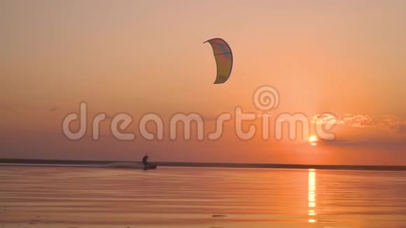 红日落在湖面上路过一个男子驾驶训练风筝视频的预览图