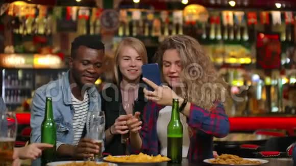在酒吧或餐馆里西班牙裔男人把Selfie和她最好的朋友团体美丽青年视频的预览图