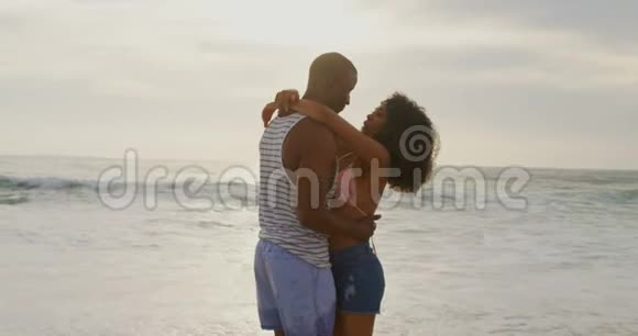在海滩上跳舞的非裔美国人夫妇的侧面景色视频的预览图