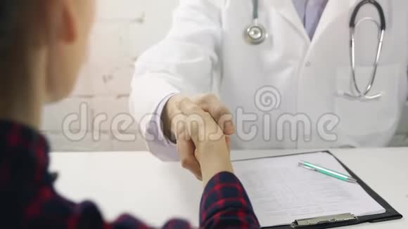 医生和病人在诊所办公室握手视频的预览图