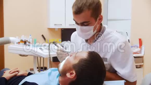 男性牙医治疗病人使用牙科仪器门诊入院视频的预览图